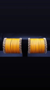 Designer yellow glass bangles with pearl metal bangles set.