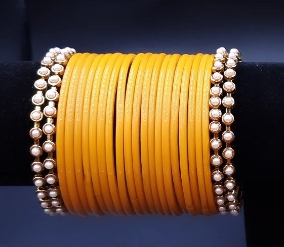 Designer yellow glass bangles with pearl metal bangles set. Designer yellow glass bangles with pearl metal bangles set.